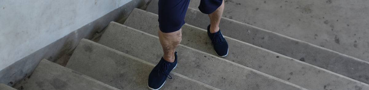 person with varicose veins climbing the stairs in sports gear.