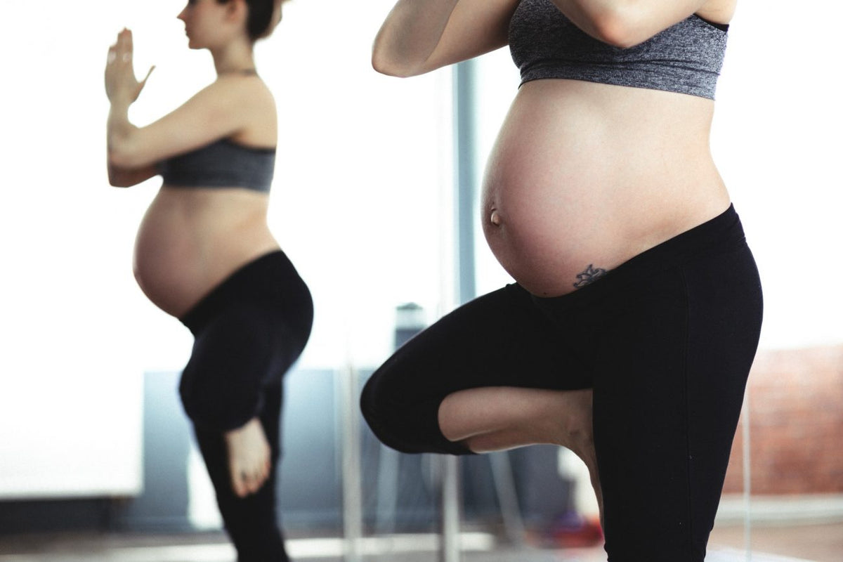 Image of woman doing yoga as one of the ways to reduce back pain during pregnancy.