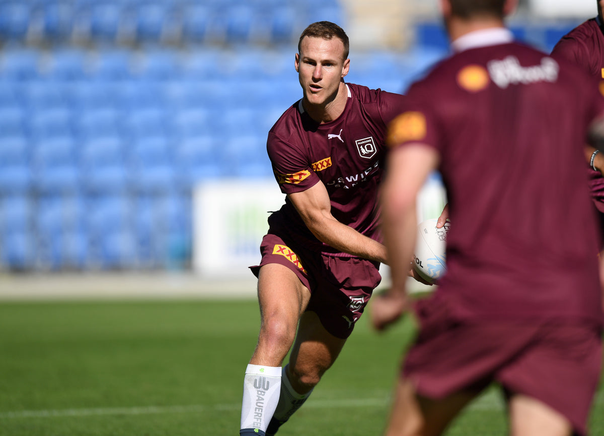 Daly Cherry Evans training with the Queensland Maroons sprinting toward the camera with the ball in hand. He's wearing Bauerdeind's Sports Compression Calf Sleeves