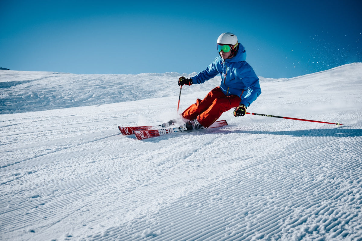 How to Prevent Ankle Injuries While Skiing, image of man skiing down a mountain