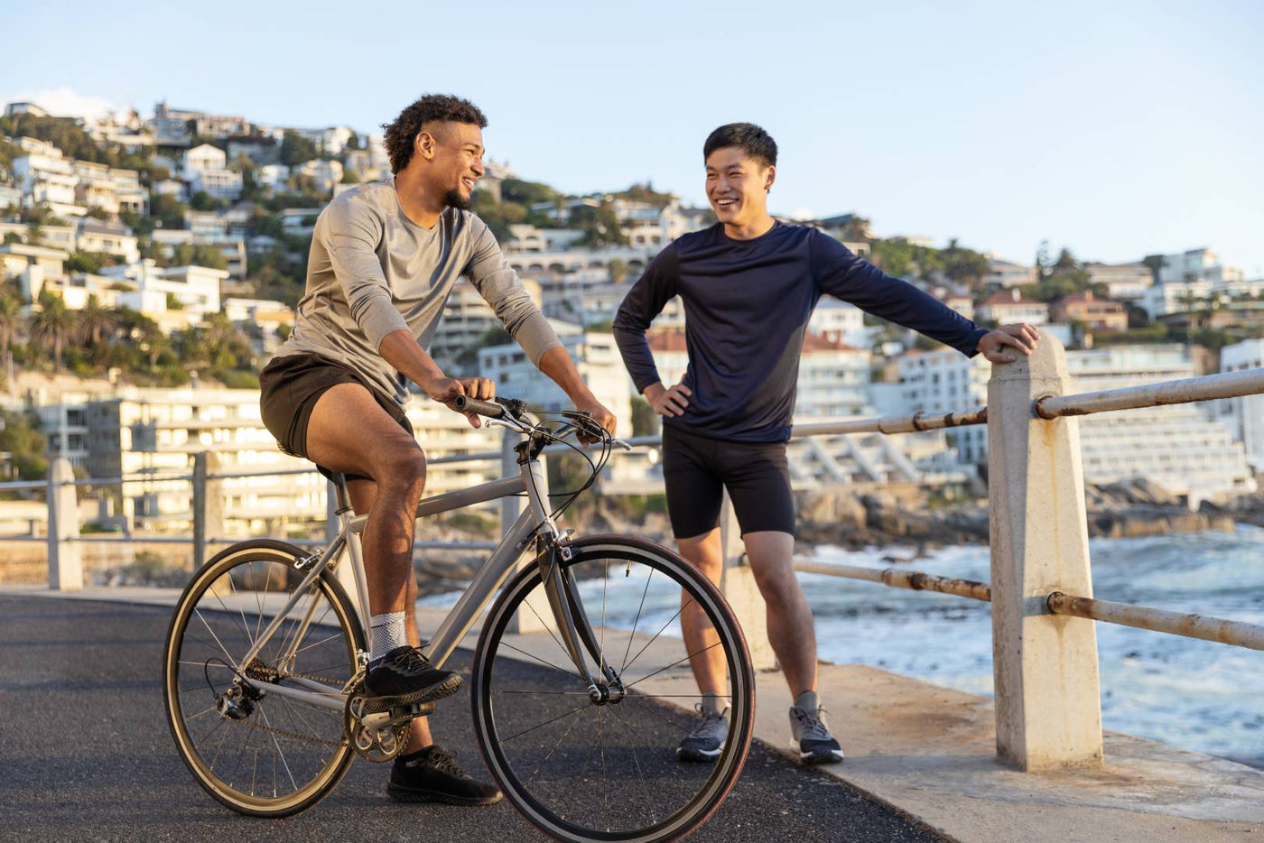 Cycling tips for beginners: man on a bike talking to his friend at bondi beach