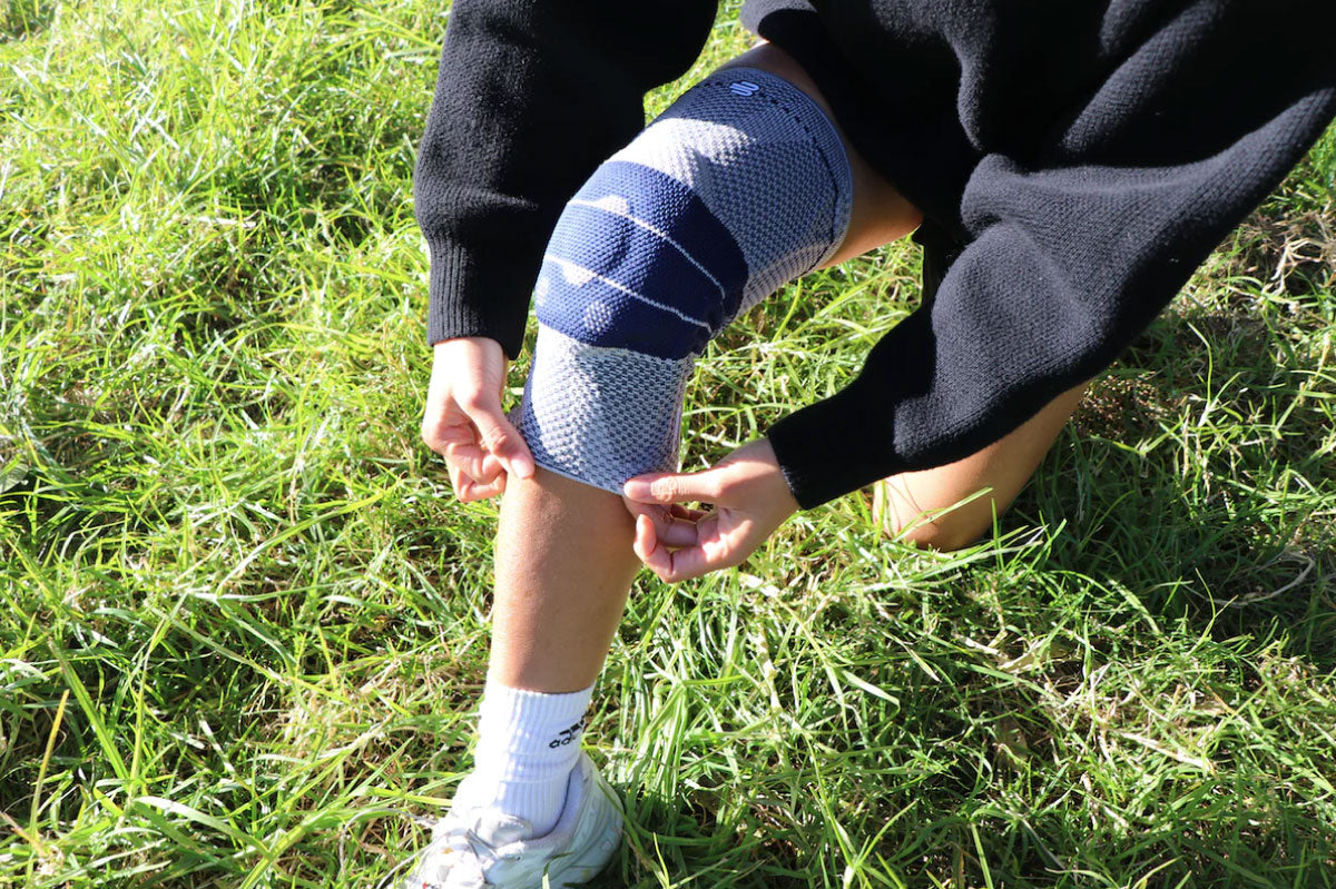 Person kneeling to adjust a well-fitted genutrain knee brace